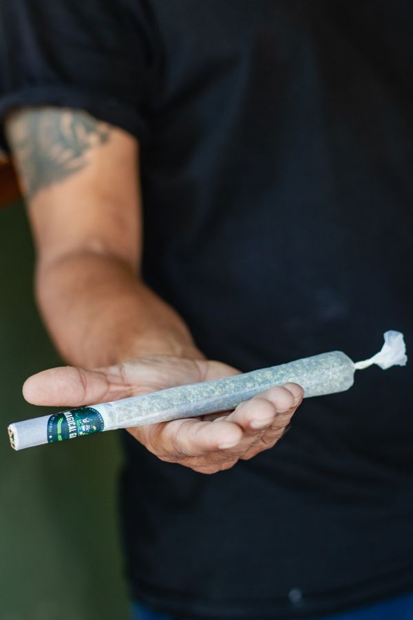 Hand holding a premium pre-rolled cannabis joint at Magical Garden, Ko Samui