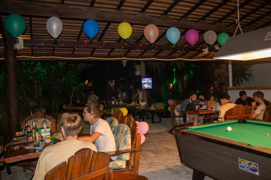 Group dining with balloons and pool table in the background at MG Bistro, Ko Samui