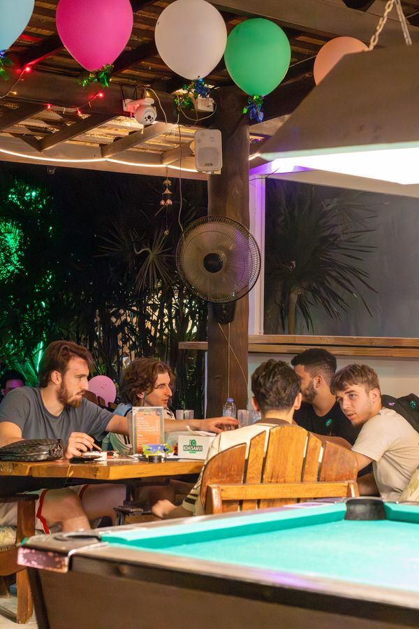 Friends playing pool and dining at Magical Garden cannabis lounge, Ko Samui