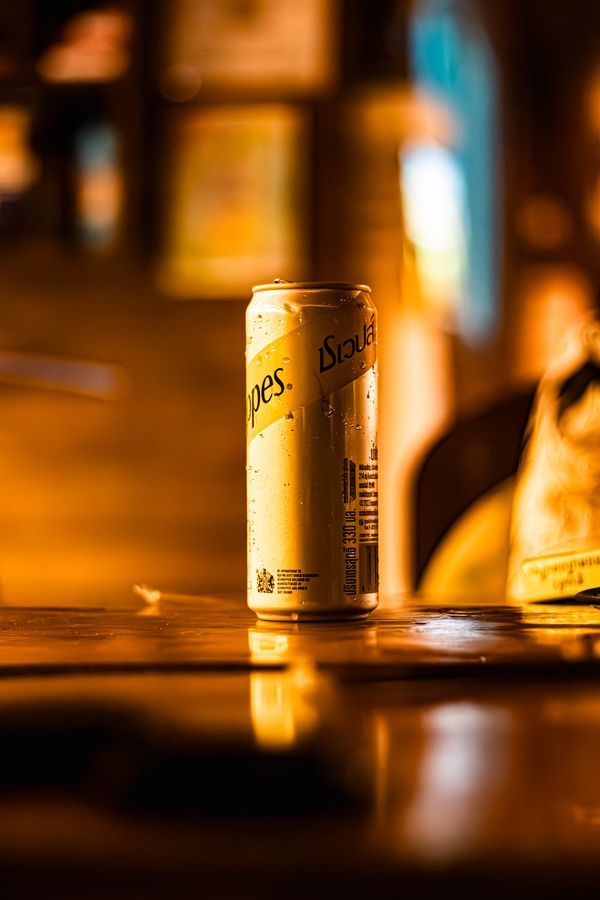 Schweppes can on a wooden table in the cosy atmosphere of Magical Garden, Ko Samui
